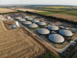 Luftaufnahme einer Biogasanlage mit mehreren Fermentern inmitten landwirtschaftlicher Felder