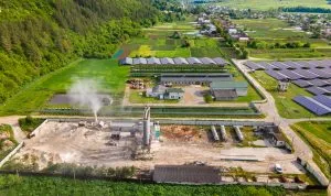 Industrieanlage mit Solarpanels und Silos inmitten landwirtschaftlicher Flächen